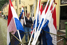 847995 Afbeelding van het ophangen van de vlaggen, ter versiering van het buurtfeest van Buurtvereniging Margriet in de ...